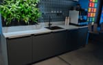 Specialbyggt kök med matchande väggpaneler, Atlas Copco showroom Sickla