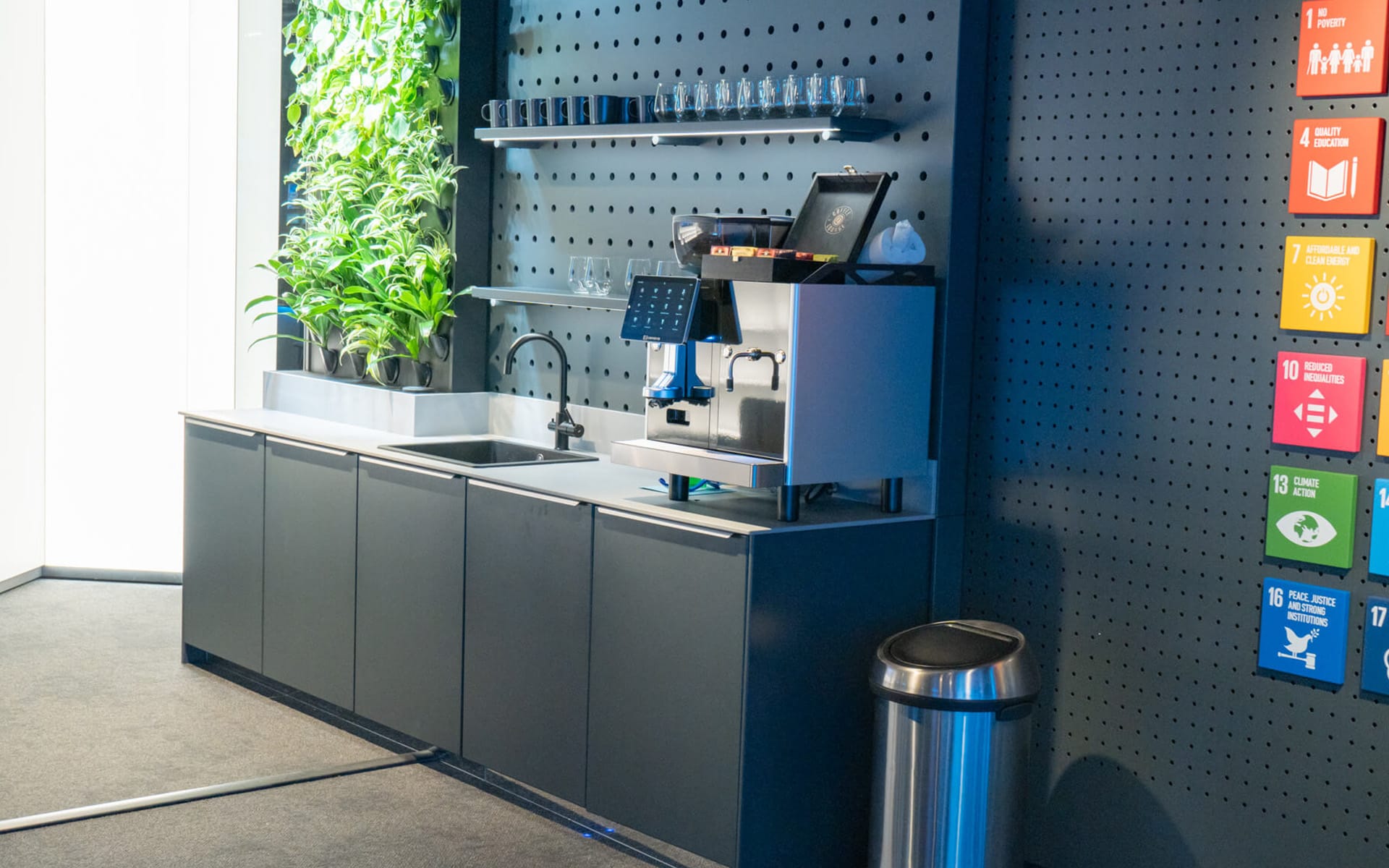Side view of custom showroom kitchen with integrated LED shelving, Atlas Copco