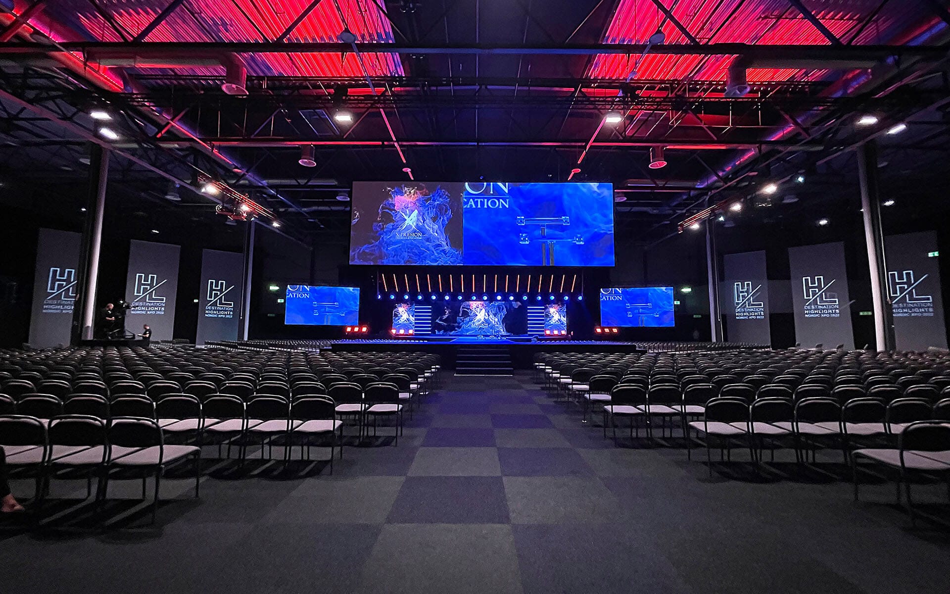 Scrim-tygsvepa med projicerad eventlogga på sidorna om scenen, Destination Highlights XPO