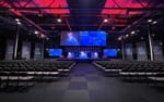 Scrim-tygsvepa med projicerad eventlogga på sidorna om scenen, Destination Highlights XPO