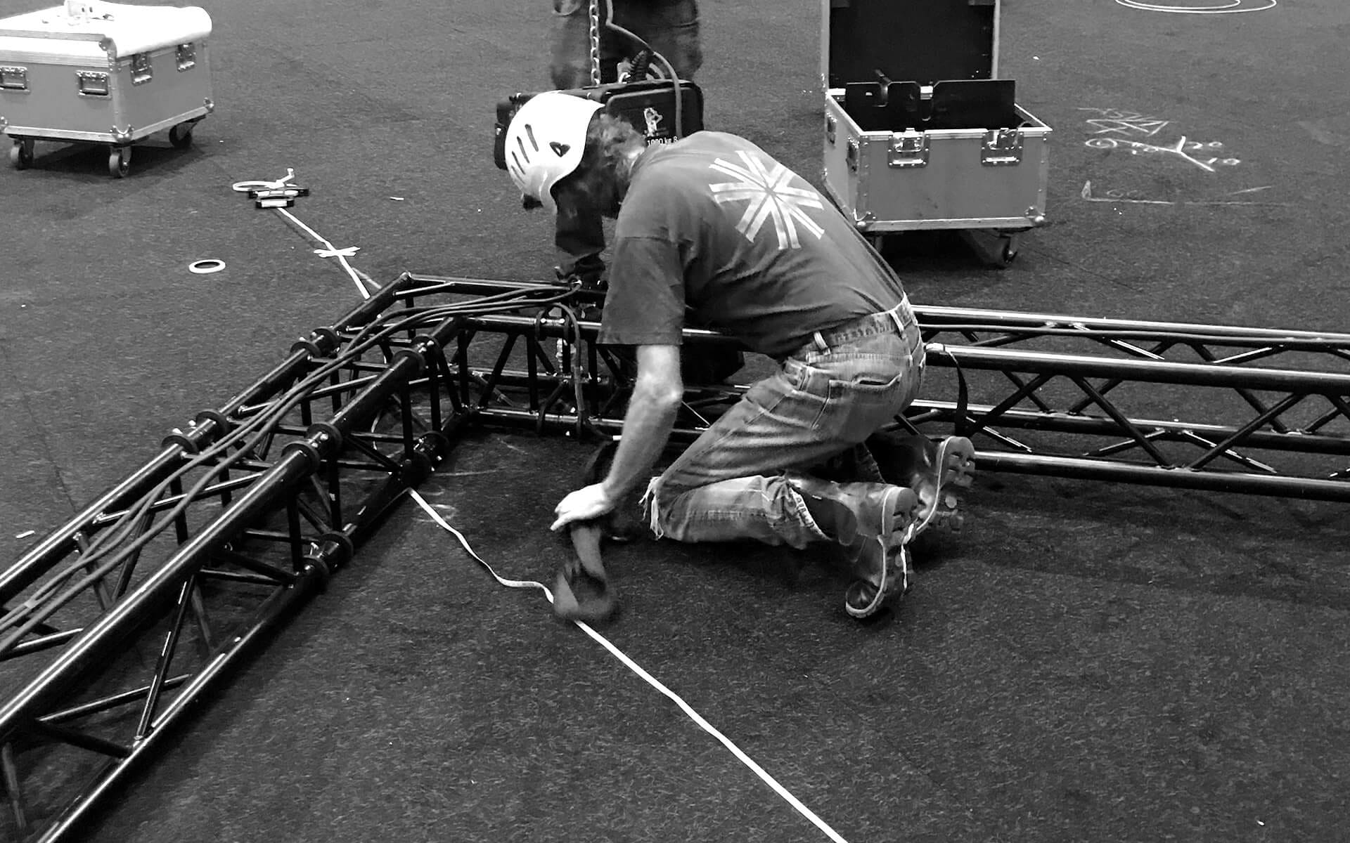 Svart tross riggad i Avicii Arena inför Dustin Expo – strukturen bär både ljus och bildlösningar.