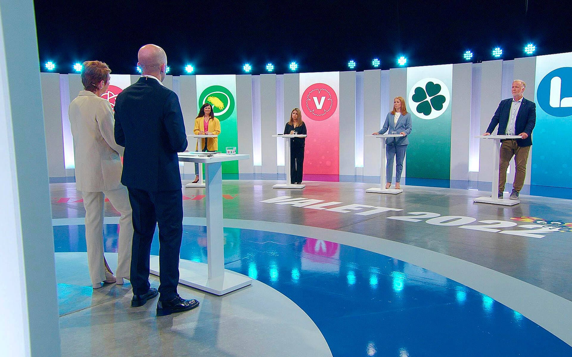 Moderators Viktor Barth-Kron and Helena Gissén in foreground, Expressen party leaders debate studio 2022