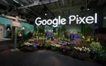 Stor bakbelyst Google Pixel-ljusskylt bakom blomsterdekor i entréinstallation, Fotografiska Stockholm