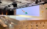 Plywoodinklädd scen med högblank vit matta och pappersflygplansdekor, Think With Google Hotel At Six