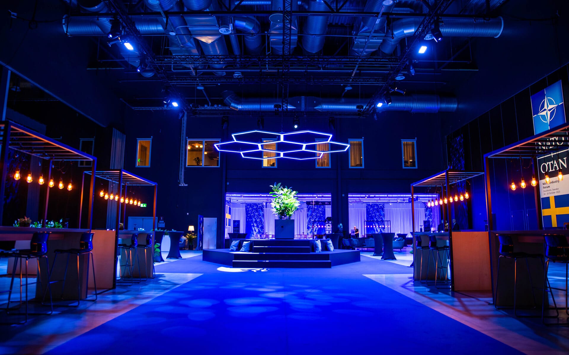Specialbyggd hexagonformad takarmatur som centerpiece i loungen, NATO Industry Forum XPO