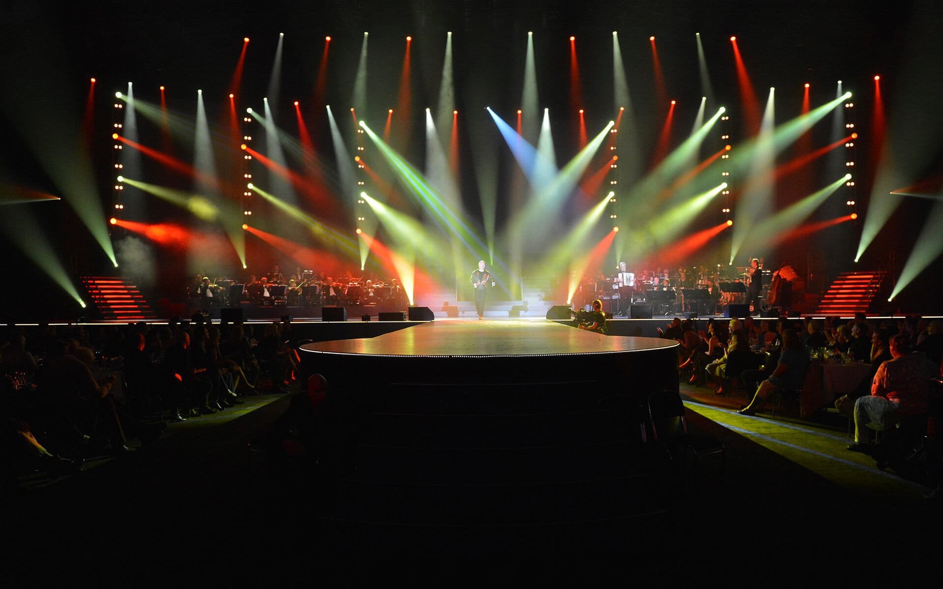 Jerry Williams on stage with lighting rig in yellow and red, Sandvik 150th anniversary Göransson Arena