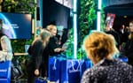 Värdinnor delar ut give-aways ur sittmöbeln i Schibsteds mässmonter, NextM Annexet