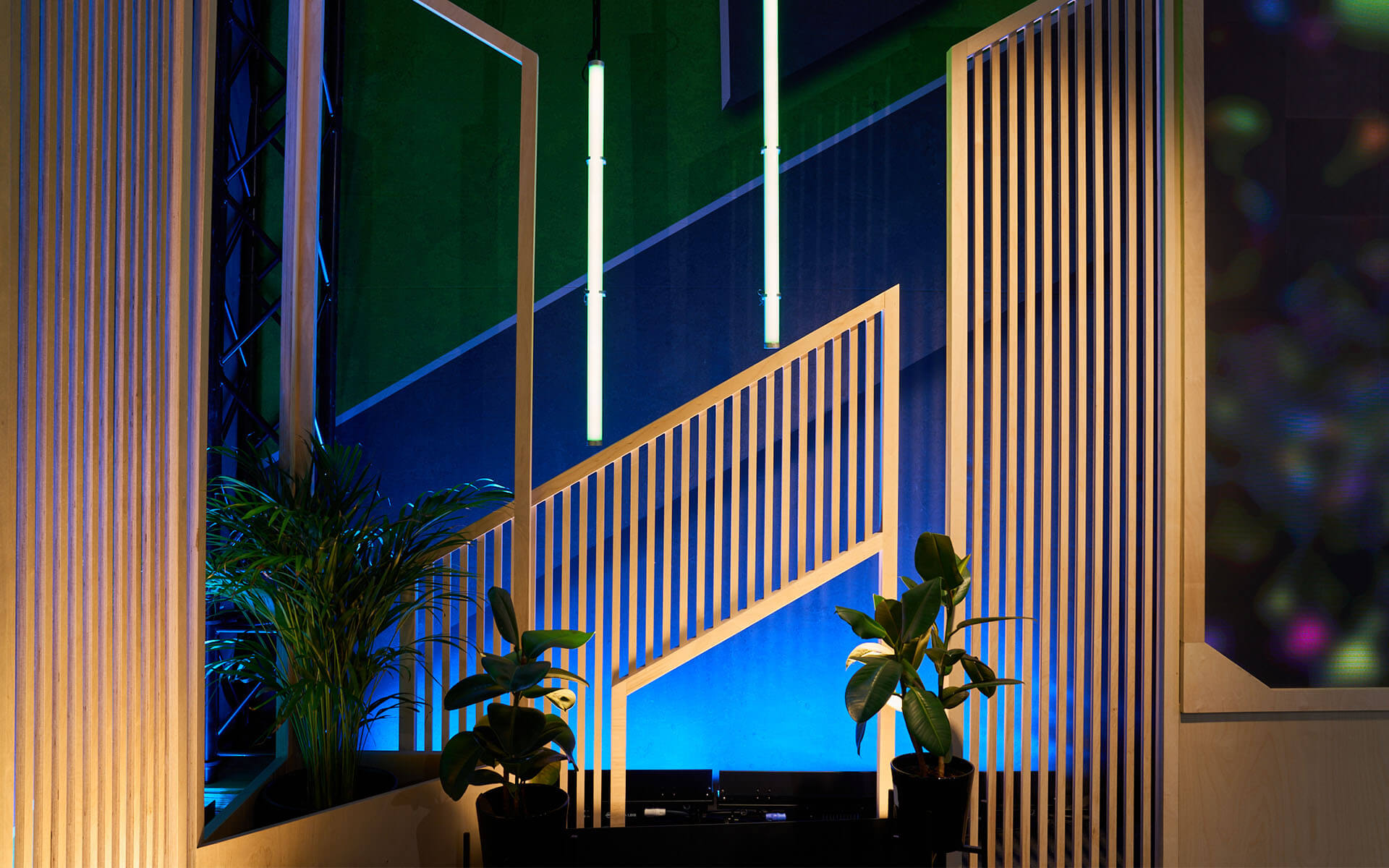 Loungemiljö med fåtöljer och gröna växter på scenen