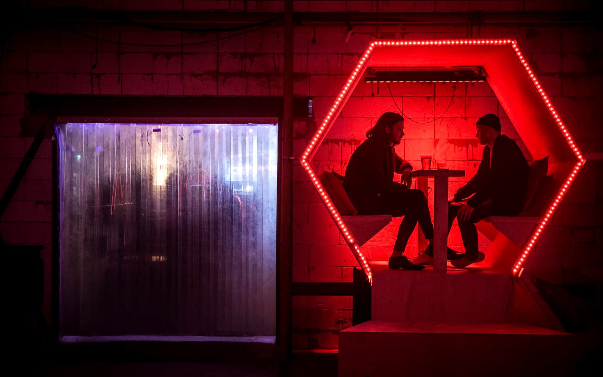 Festival goers sitting in hexagon with built-in seating, Estrella lounge Sónar 2016